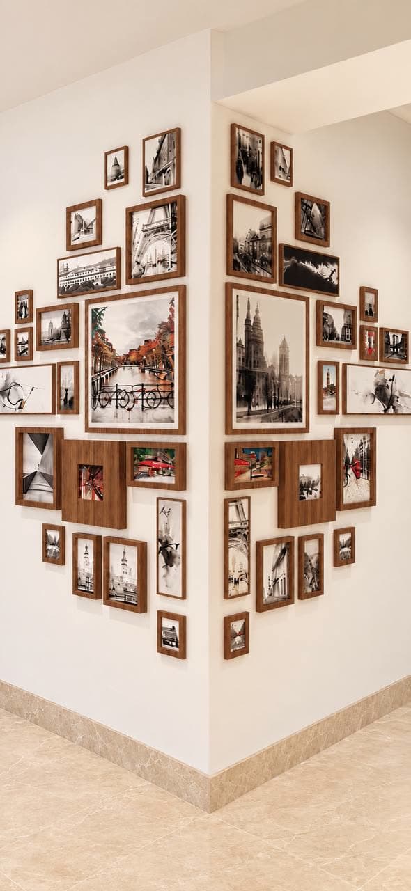 Symmetrical arrangement of walnut-framed city photographs wrapping both sides of an outside corner.