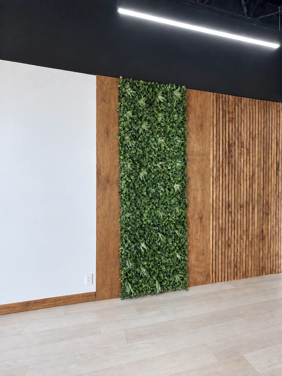 Commercial wall of stained wood panels and slats with a full-height preserved moss panel set into it.